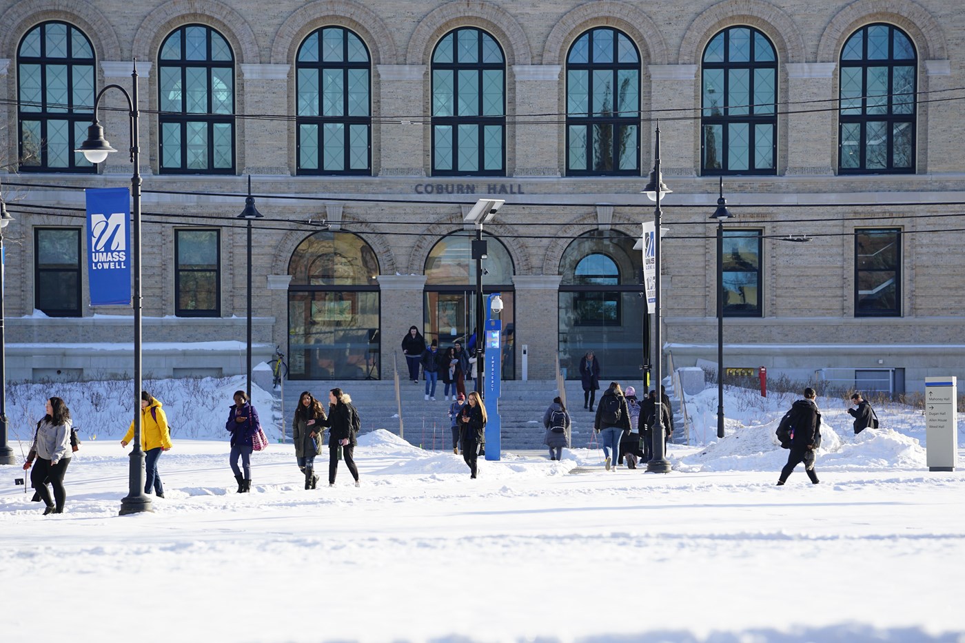 Students walking across the snow-covered South Campus quad with Coburn Hall in the background 