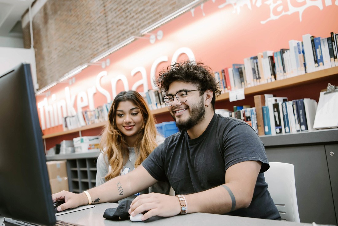 Two students work on computer