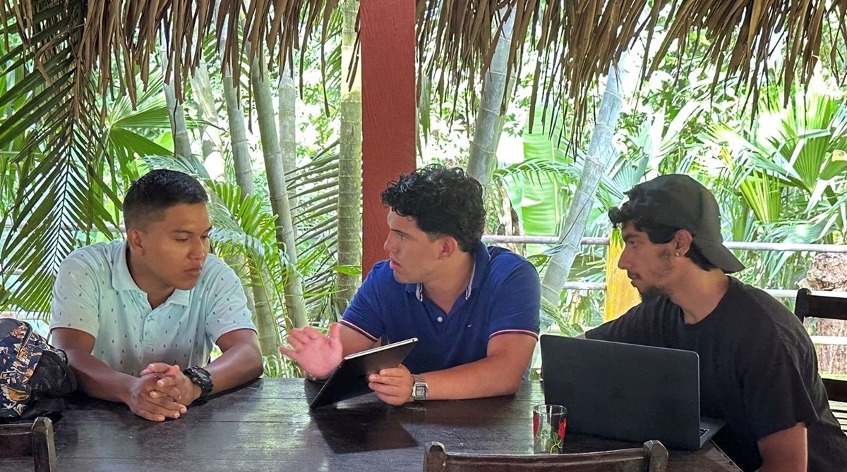 UMass Lowell students Fidel Castro and Corey Perez speak with a farmer in Pananma