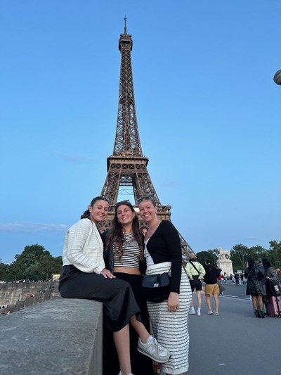 3 UMass Lowell Study Abroad students pose in front of the Eiffel Tower in Spring 2024.