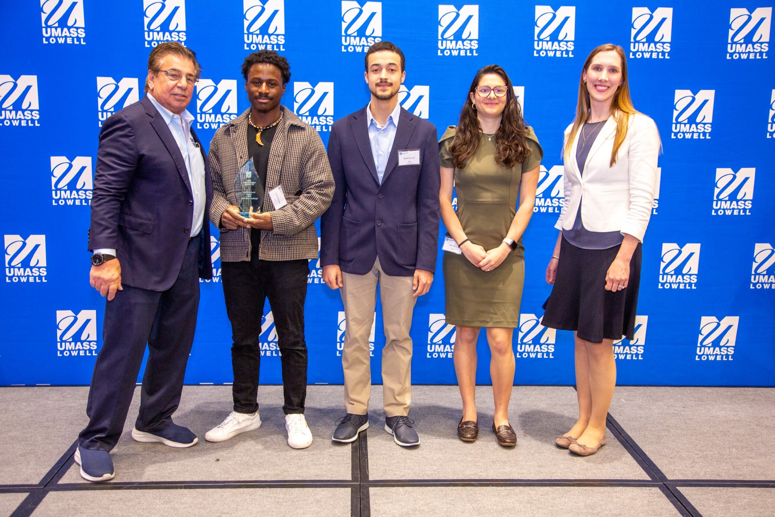 Team ZENYAI posing for a picture with Brian Rist and Holly Lalos after receiving an award.